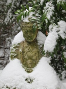 A Buddha on the zendo trails during a winter snowstorm.
